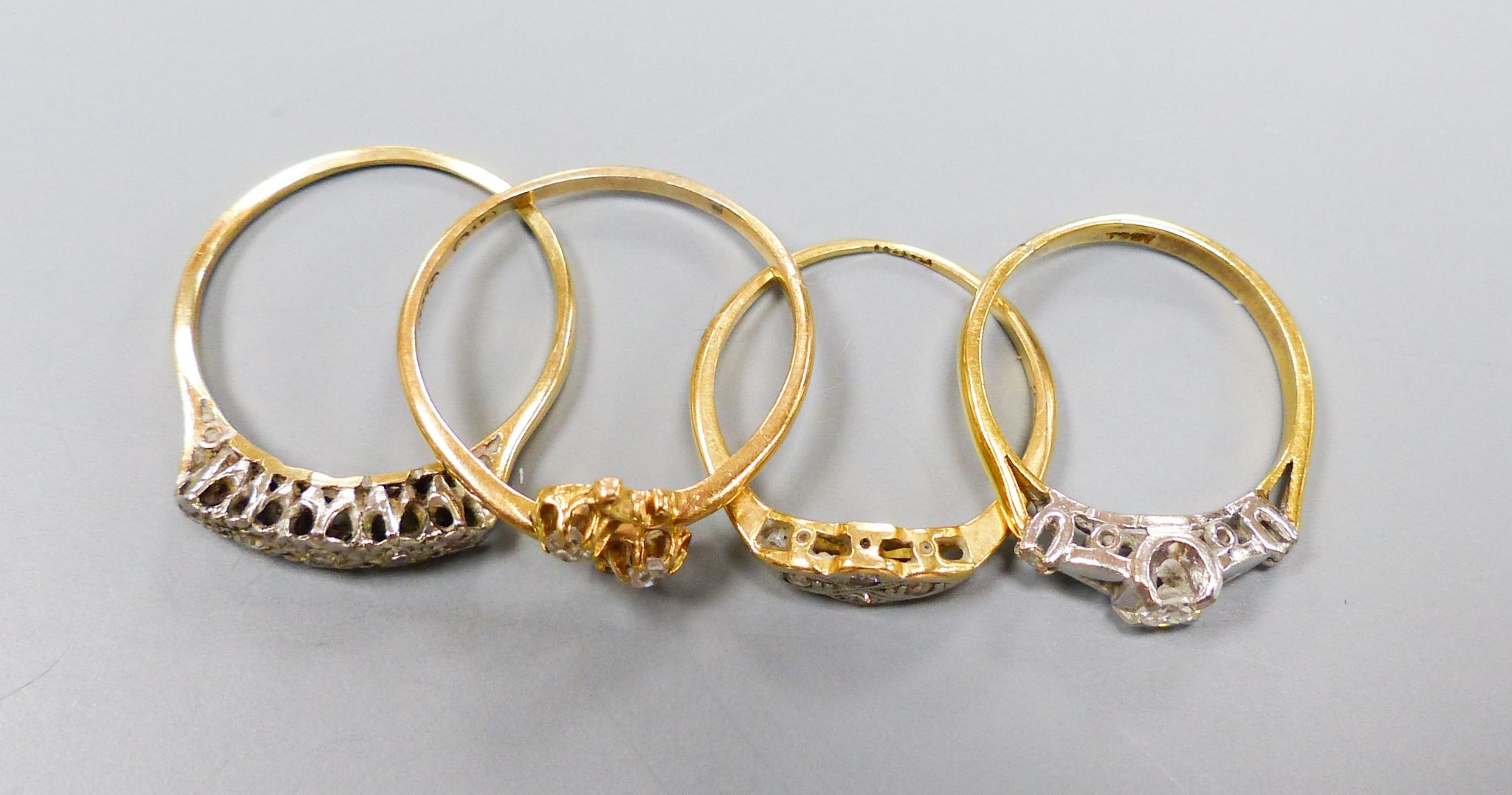 Three assorted 18ct and diamond set rings, including two stone crossover, gross 6.5 grams and a yellow metal and five stone illusion set diamond half hoop ring, gross 2.1 grams.